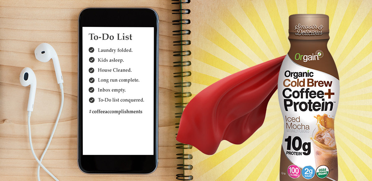 A smartphone with a to-do list on the screen and white earphones beside it lies on a wooden table. A notebook is open next to it. Beside the notebook is an Orgain Organic Cold Brew Coffee + Protein bottle wearing a red superhero cape.