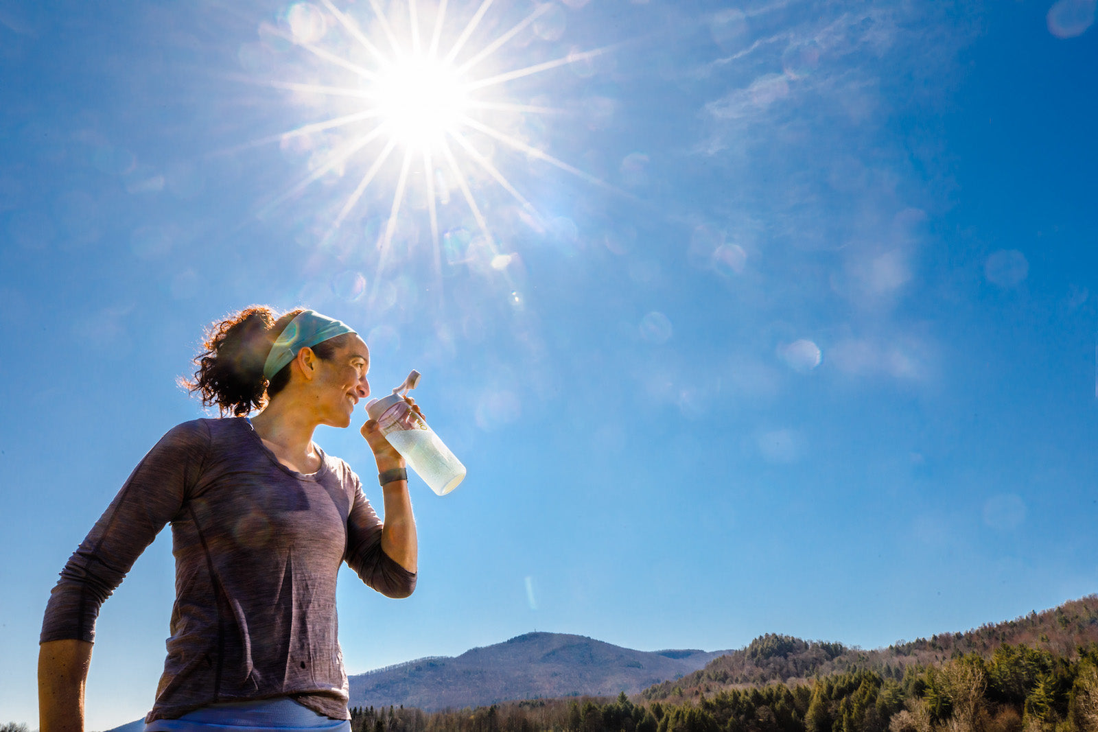 Woman drinking hydroboost out of a plastic bottle
