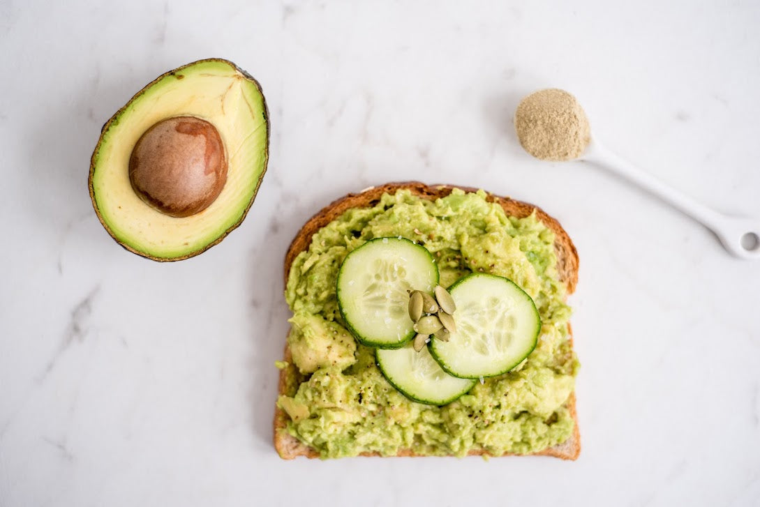 top down view of avocado toast with cucumbers