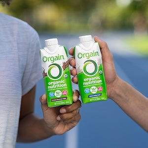 two people holding orgain organic nutrition shakes