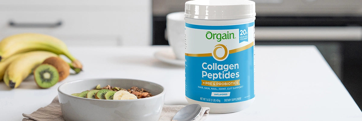 collagen peptides plus probiotics on a table next to a bowl of fruit