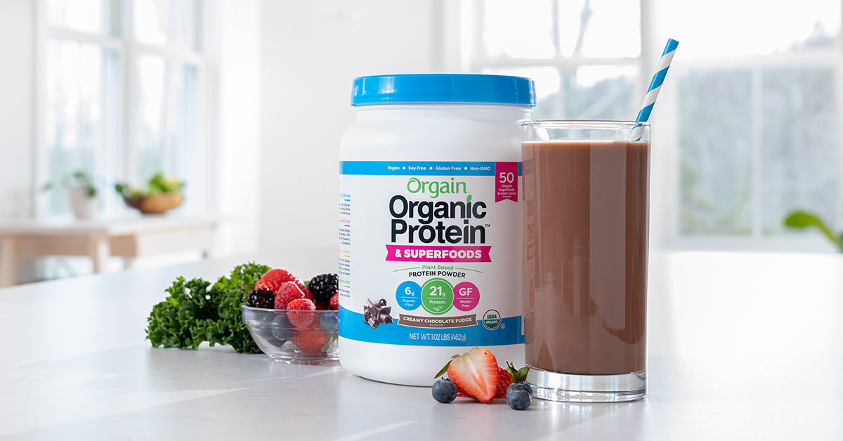 orgain organic protein powder plus superfoods powder container next to a smoothie