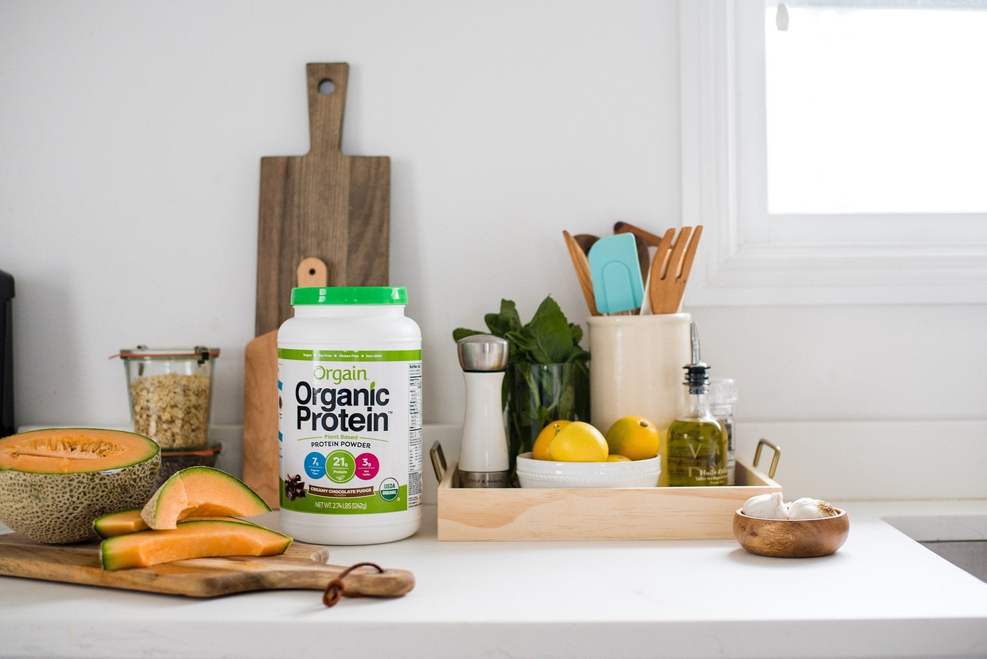 A tub of Organic Protein powder sitting on a modern kitchen counter.