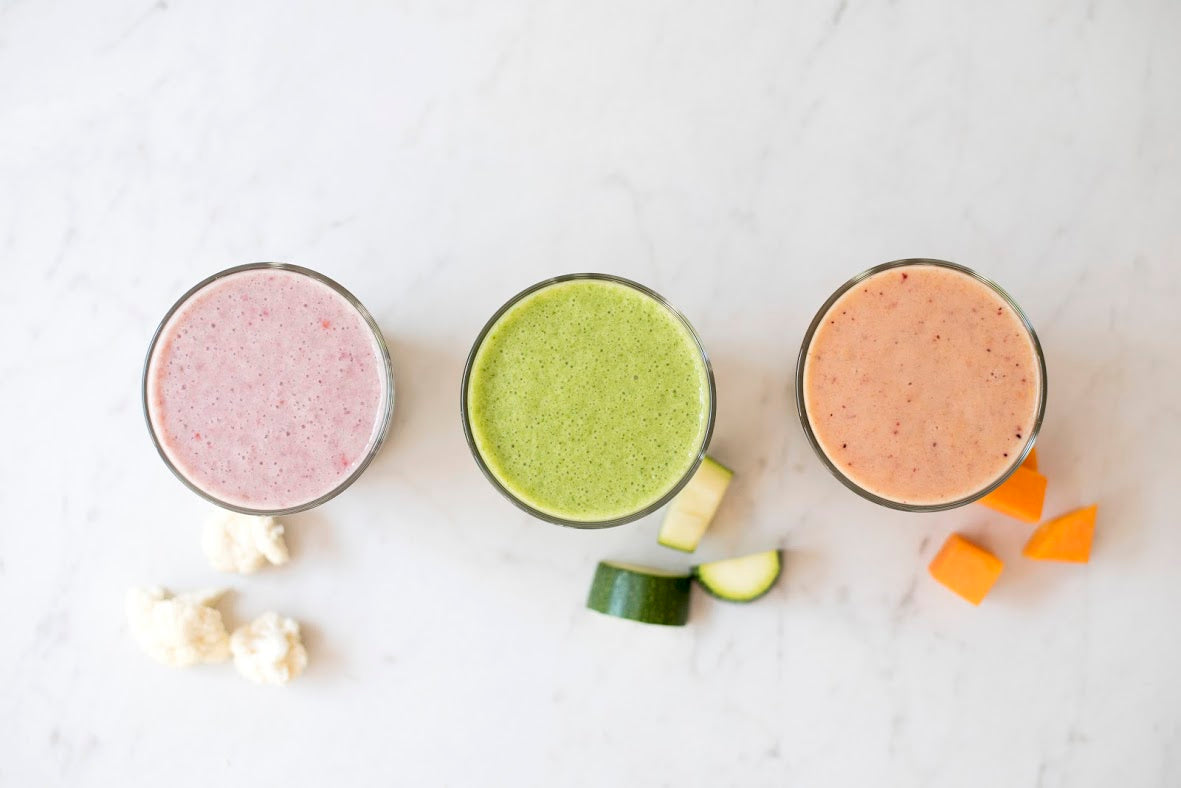 Three smoothies using Orgain products sitting on the counter