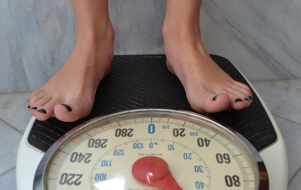 A ground-level view of a woman's feet on a scale.