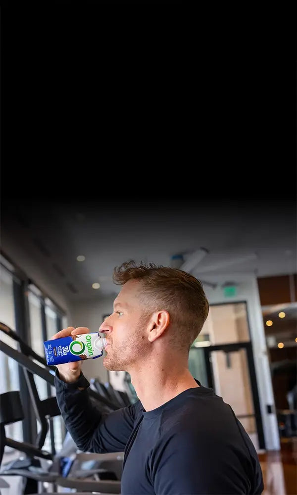 Man drinking 30g protein shake while walking on the treadmill