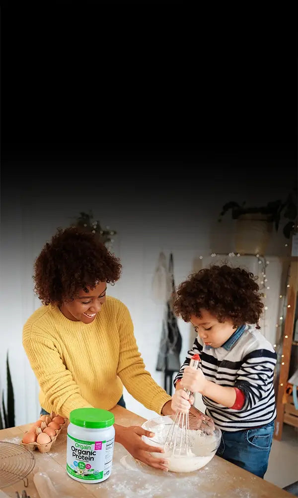 Woman baking with an child while using vanilla flavored orgain protein powder