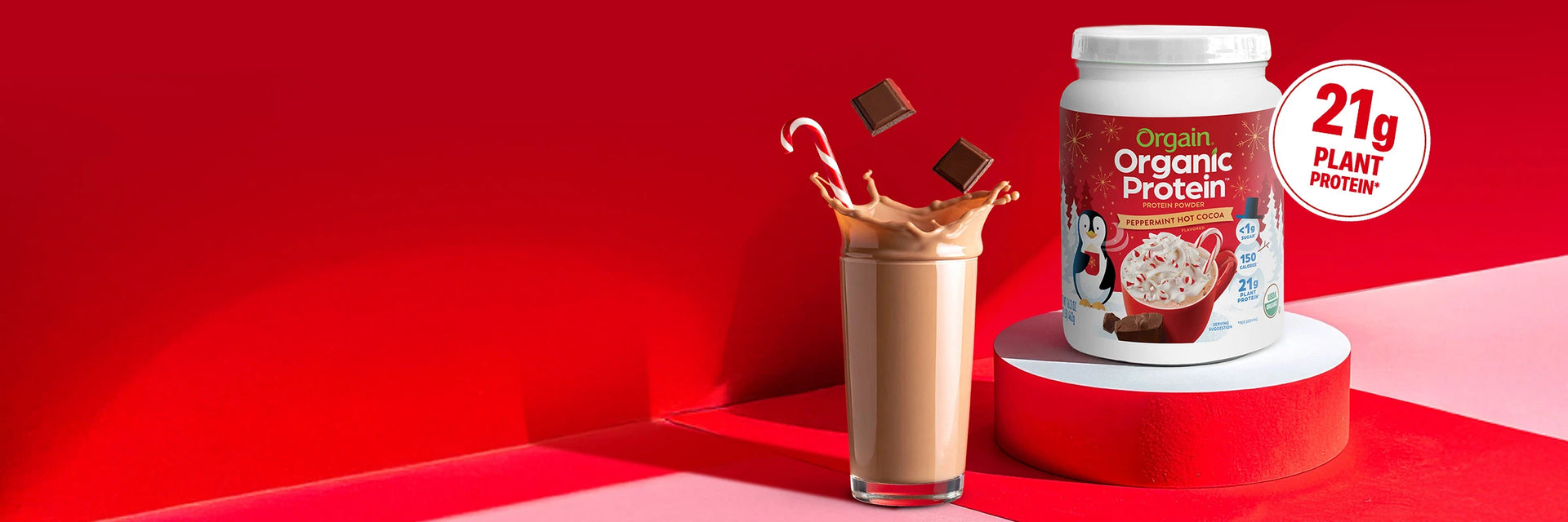 Protein supplement container with a glass of protein shake on a red background