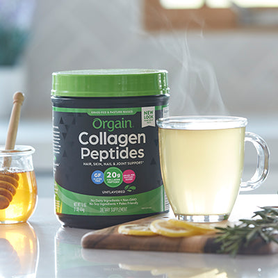 collagen peptides powder canister next to a hot cup of tea