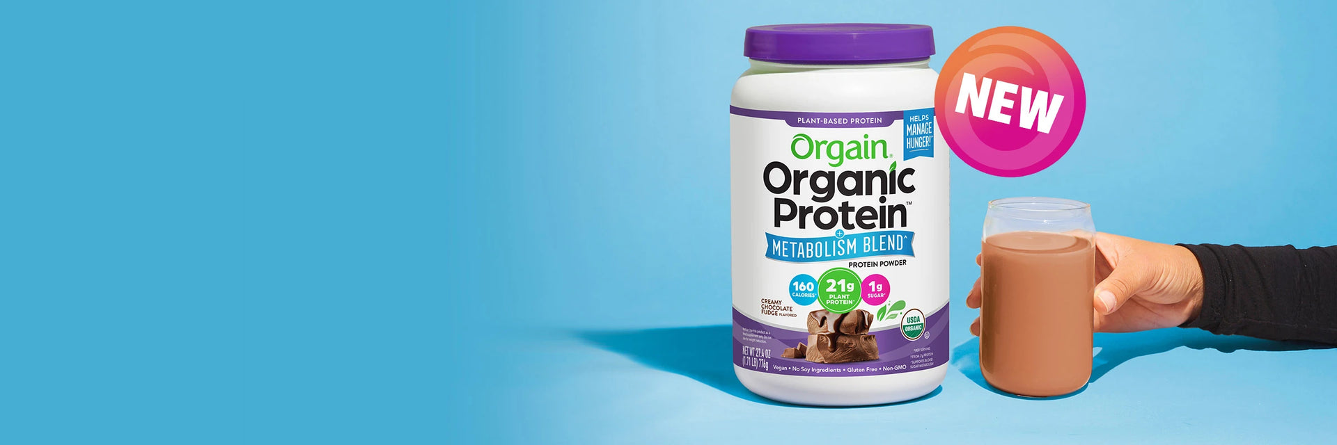 Orgain Organic Protein container with a hand holding a protein shake against a blue background